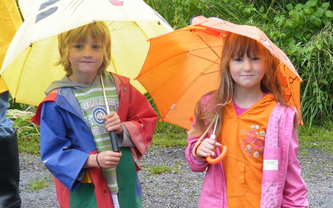 2 kleine Kinder mit Regenschirmen