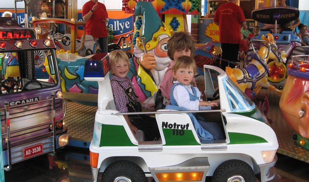 Kinder in Polizeiauto fahren Karussell auf dem Rosenheimer Herbstfest