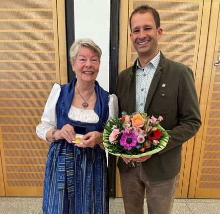 Inge Ilgenfritz steht links im Dirndlkleid. Rechts Oberbürgermeister März mit Blumenstrauss