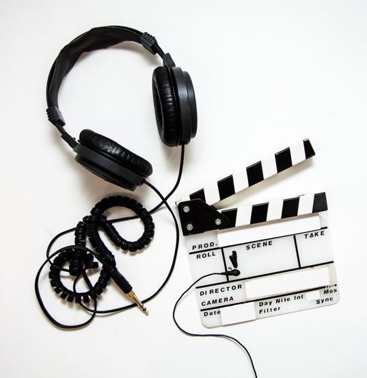 Kopfhörer, Regieklapp, Kabel auf weißem Grund