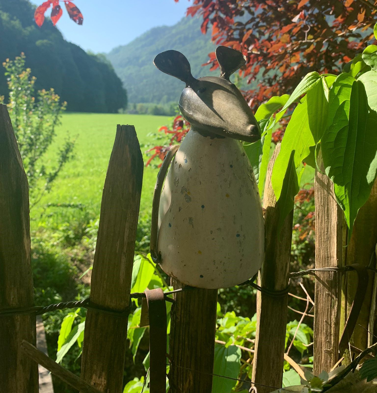 Garten in Brannenburg: Zaunfigur Maus vor Bergkulisse