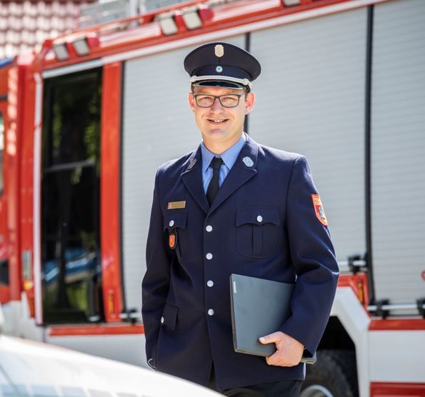 Hubert Hobmaier in Feuerwehruniform vor Feuerwehrauto