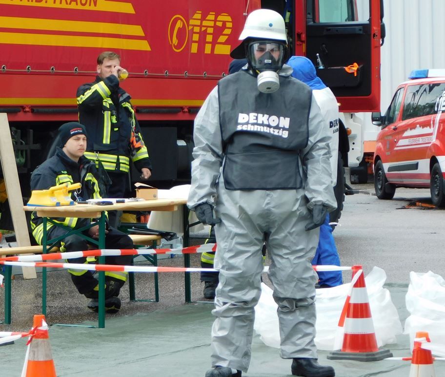 Feuerwehrmann im Schutzanzug bei Uebung im Atomkraftwerk Isar bei Landshut vor Feuerwehrauto