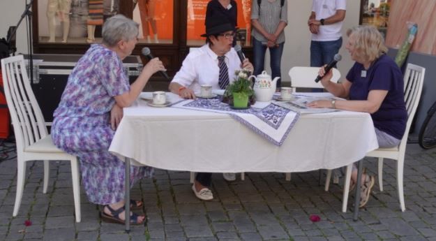 Drei Frauen sitzen um einen Tisch mitten auf dem Max-Josefs-Platz