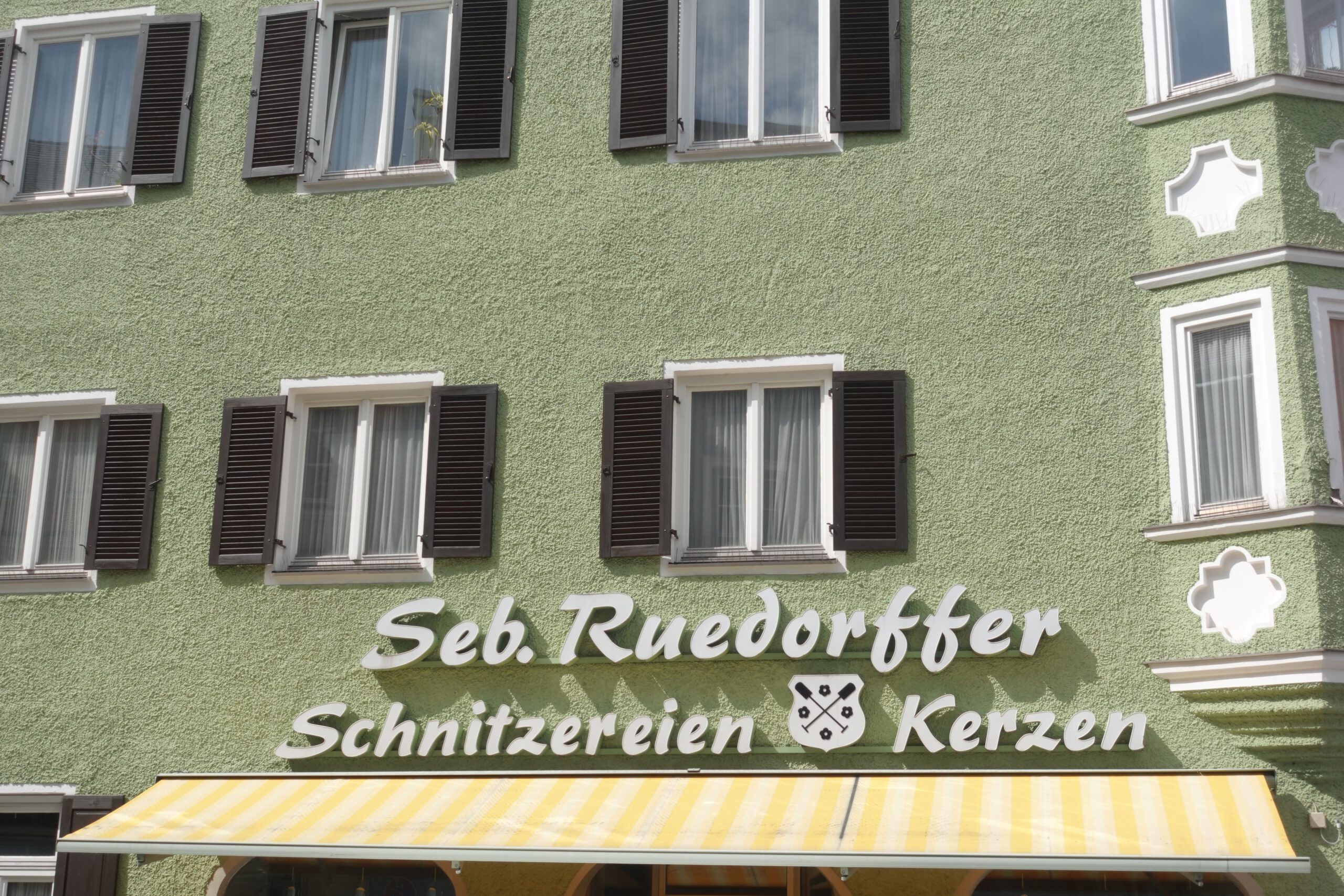 Fassade in grün mit Schriftzug des Kerzenfachhandel Ruedorffer in Rosenheim