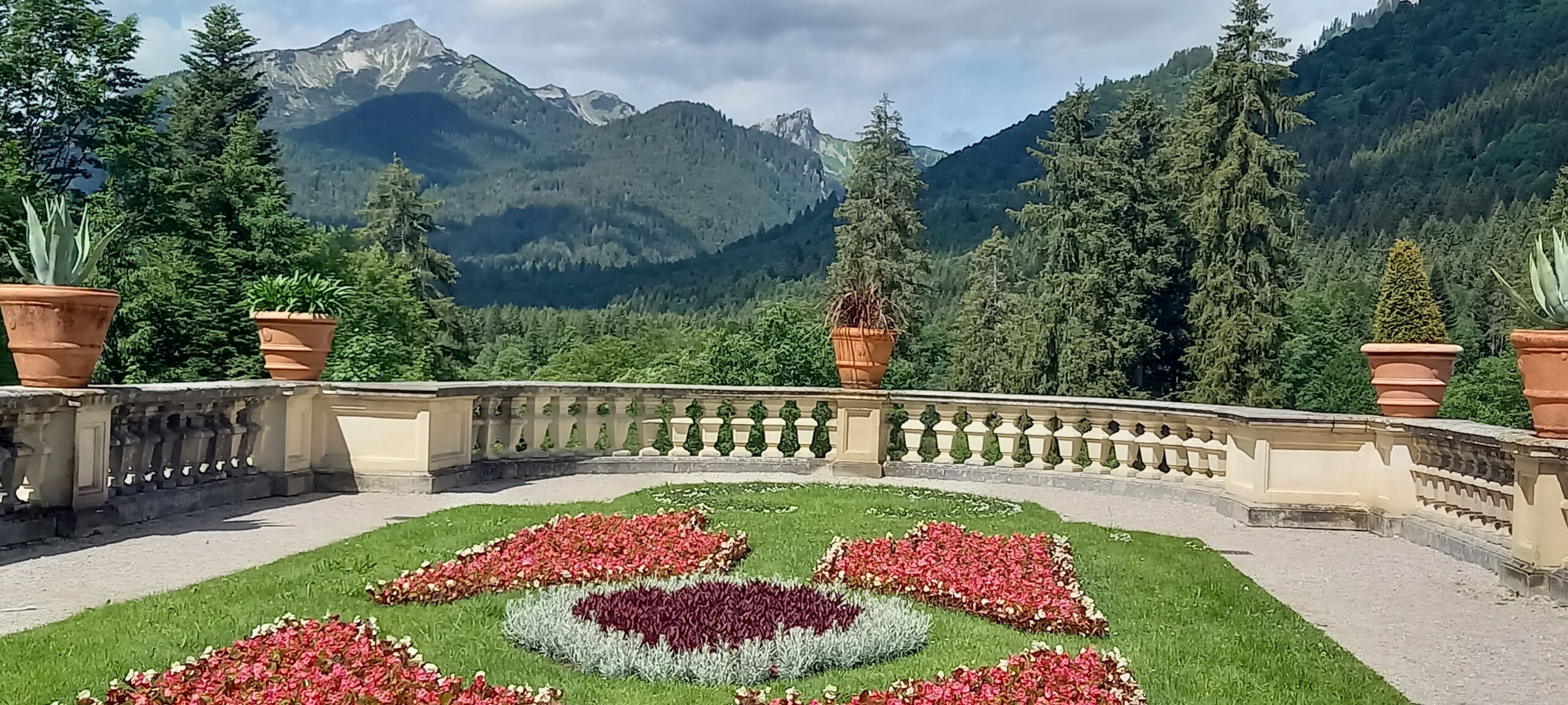 Schloss Linderhof. Blick auf Blumenbeet hin zu der Bergkulisse