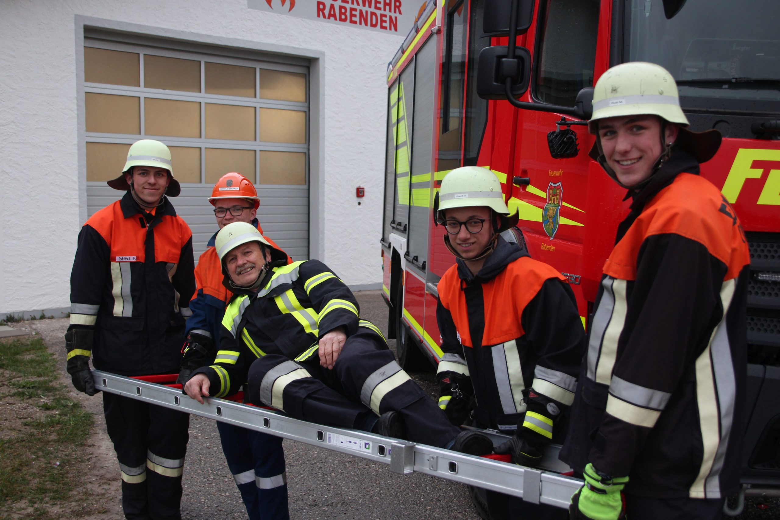 Konrad Haller lässt sich von jungen Feuerwehrlern auf einer Leier tragen