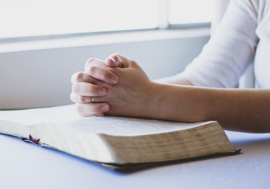 Betende Hände über einer Bibel