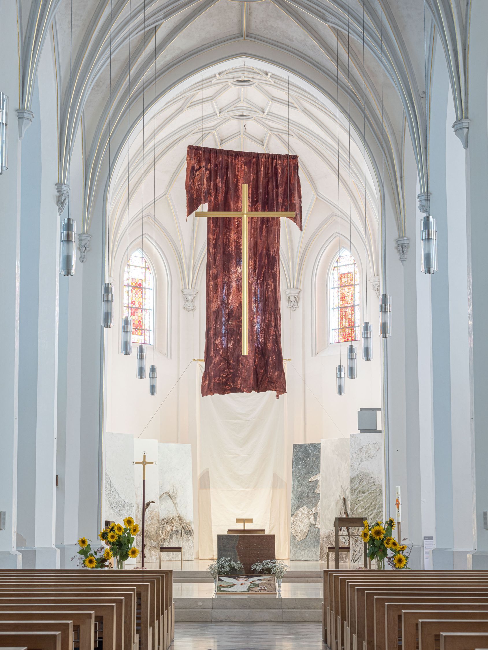 Installation in der Kirche St. Nikolaus in Rosenheim - Riesiges rotes Gewand mit Kreuz haengt im Altarraum von der Decke