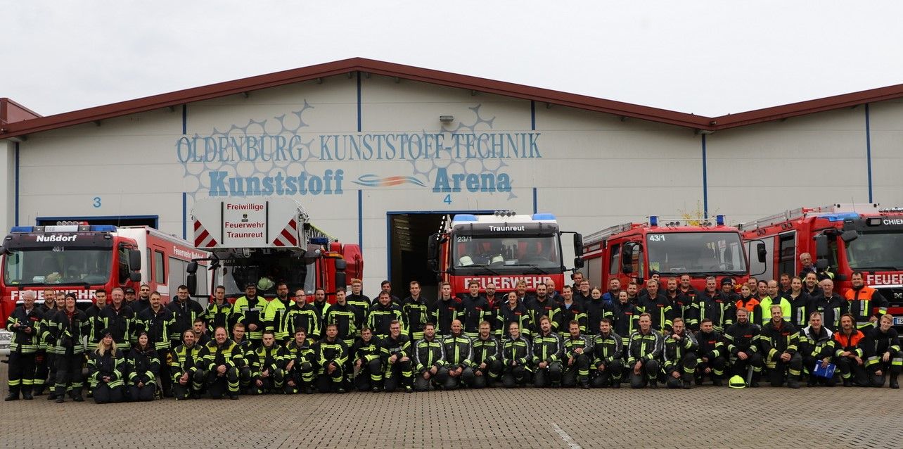 Rund 100 Feuerwehrleute mit Feuerwehrauto vor Feuerwehrhaus in Chieming im Landkreis Traunstein