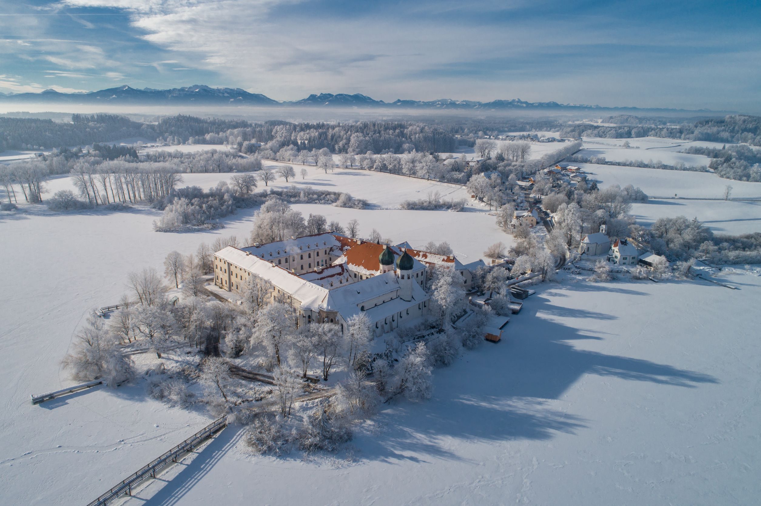Blick von oben auf Kloster Seeon im Winter mit viel Schnee
