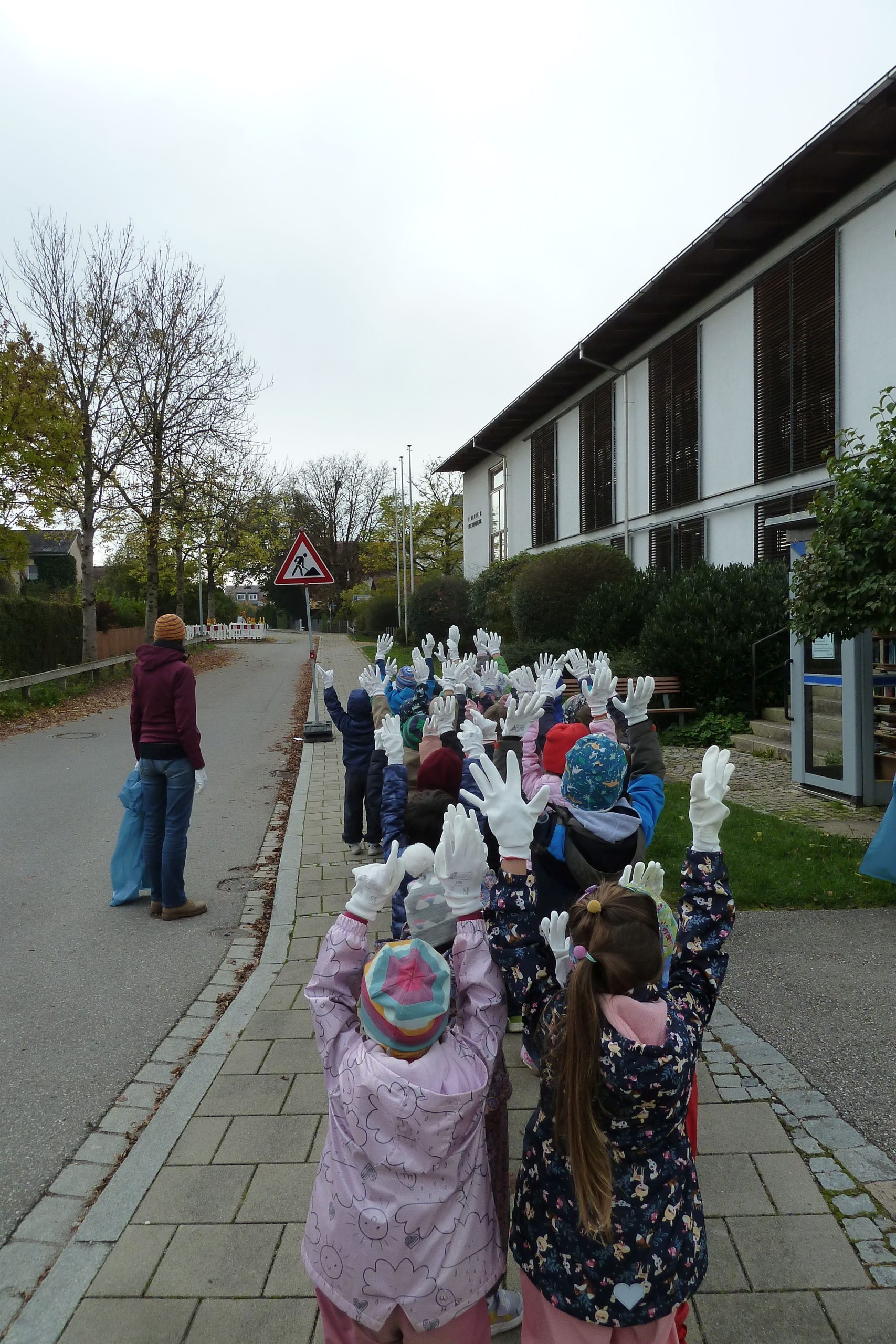 Kinder mit weißen Handschuhen - Hände in der Höhe, von hinten auf dem Weg zum Sammeln