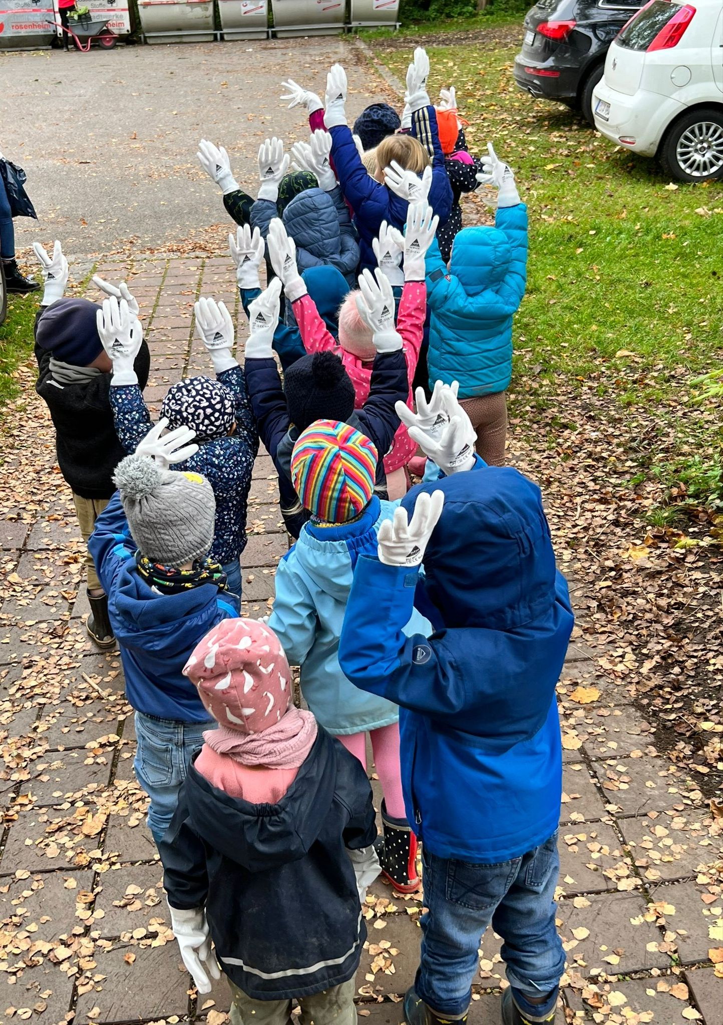Kinder von hinten mit erhobenen Händen auf dem Weg zum Sammeln
