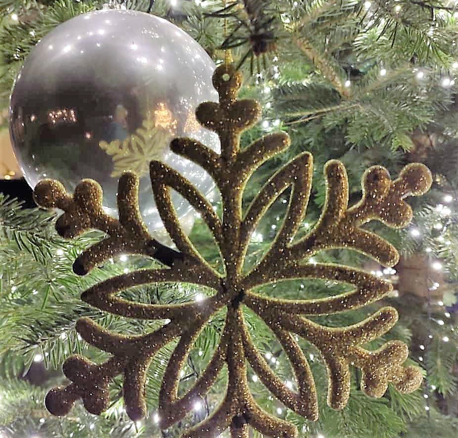 Silberne Weihnachtskugel und goldener Weihnachtstern an einem Weihnachtsbaum - Nahaufnahme