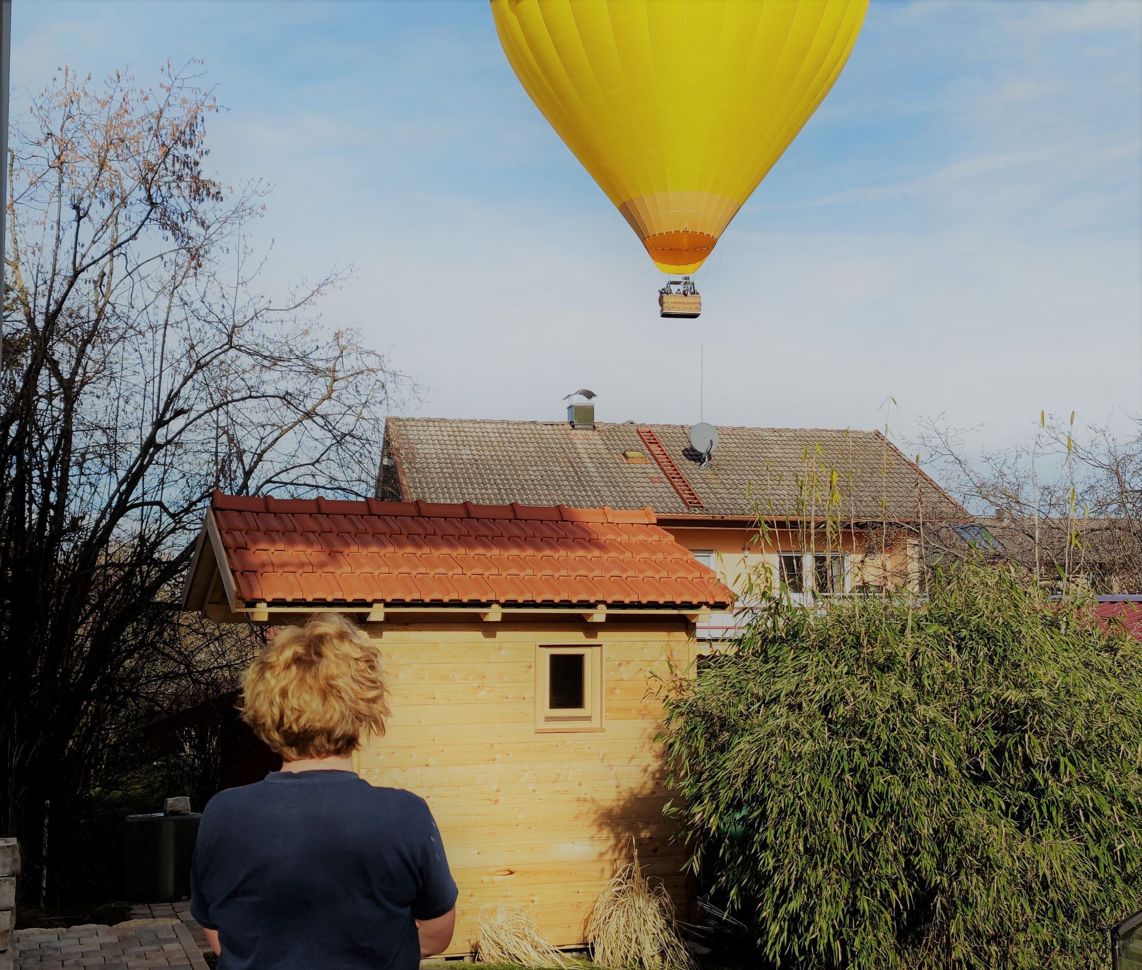 Gelber Heißluftballon knapp über Hausdach in Traunstein