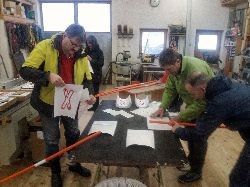 Zwei Männer bekleben die Mahnstäbe für die Protestaktion für den Brennernordzulauf im Landkreis Rosenheim