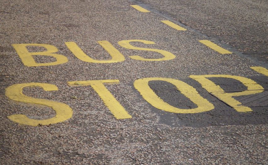Bus Stop Schriftzug in Gelb auf Straße