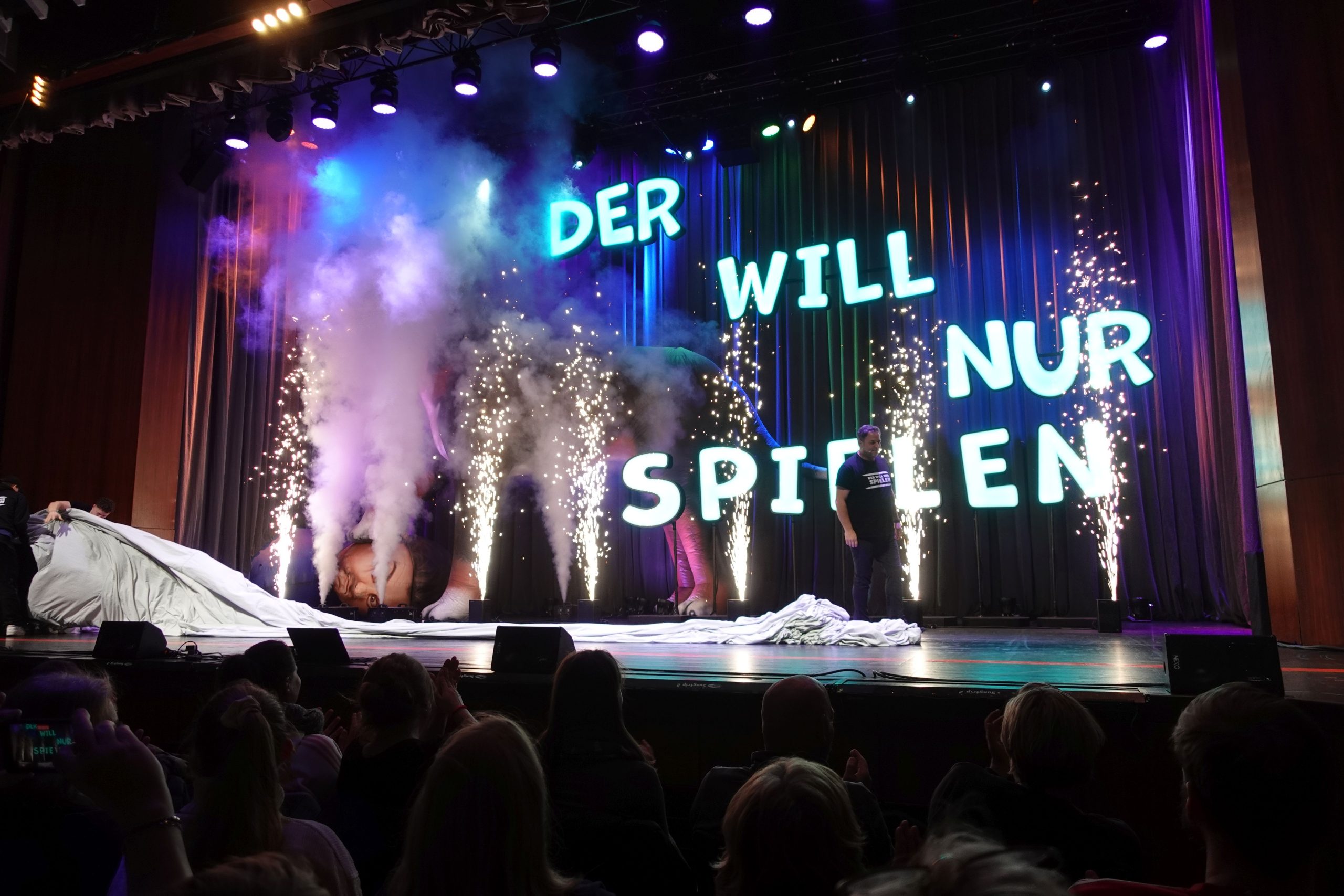 Hundeprofi Martin Rütter tritt bei seinem Auftritt in Rosenheim begleitet von Bühnenfontänen die Bühne