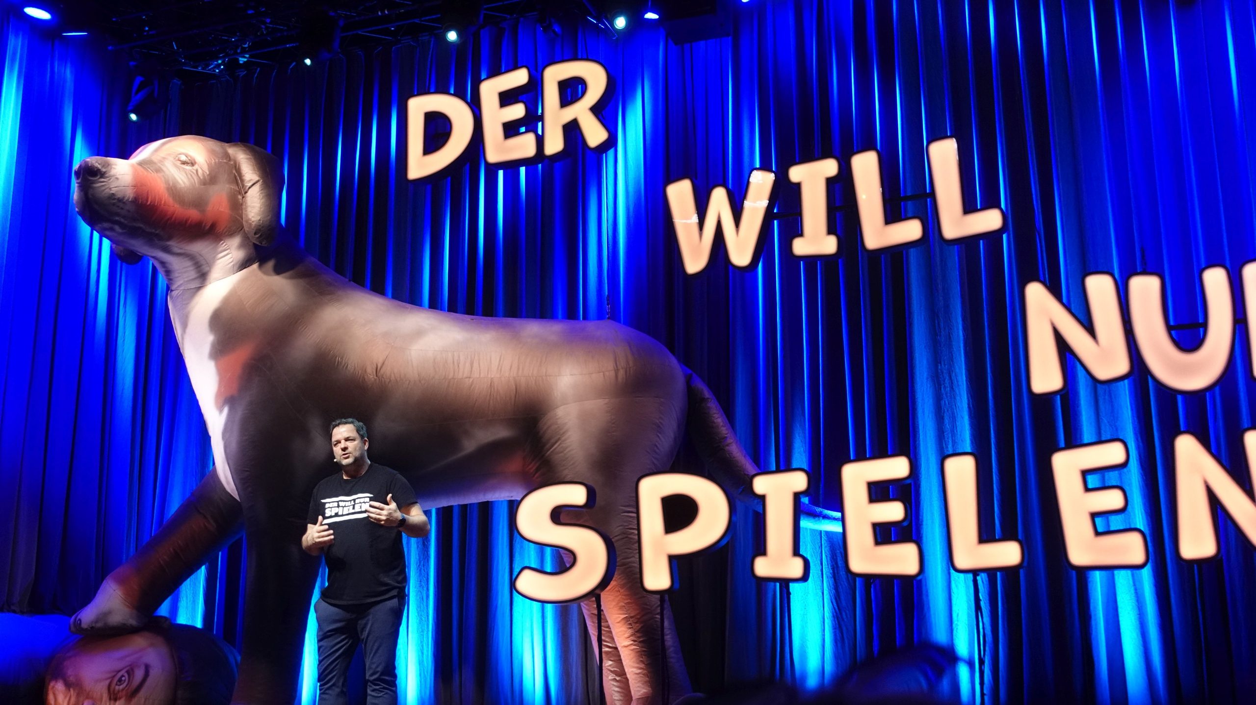 Martin Rütter mit überdimensionalen Aufblashund auf der Bühne im Kultur- und Kongresszentrum Rosenheim