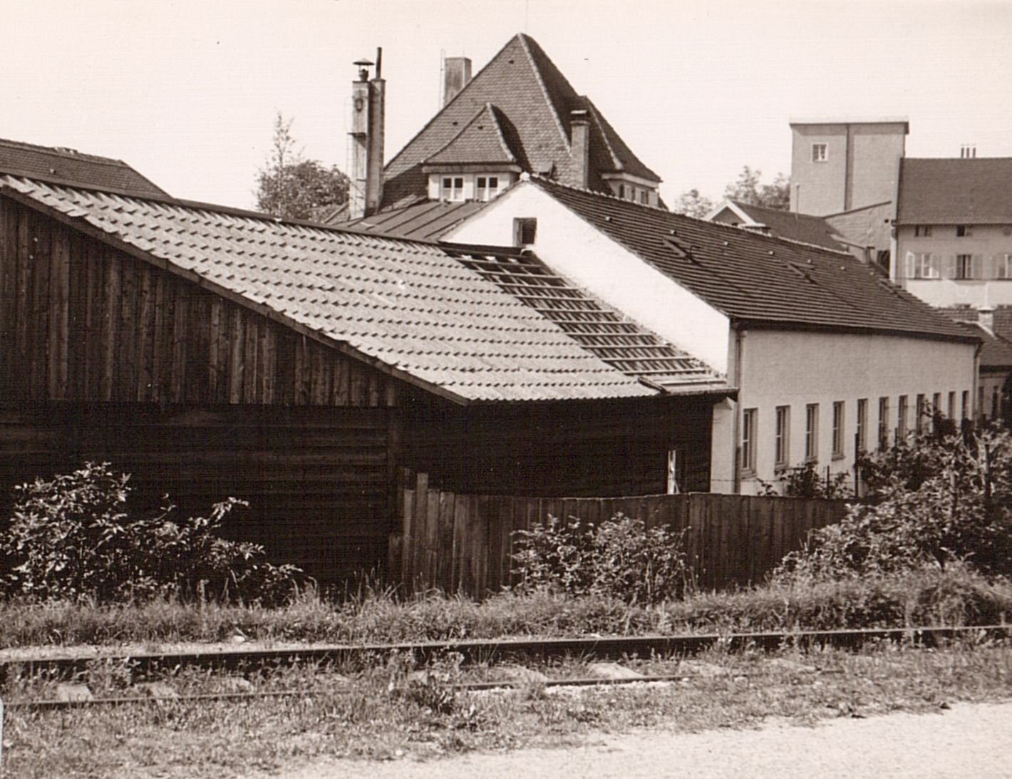 alte Gebäude vor einem Gleis