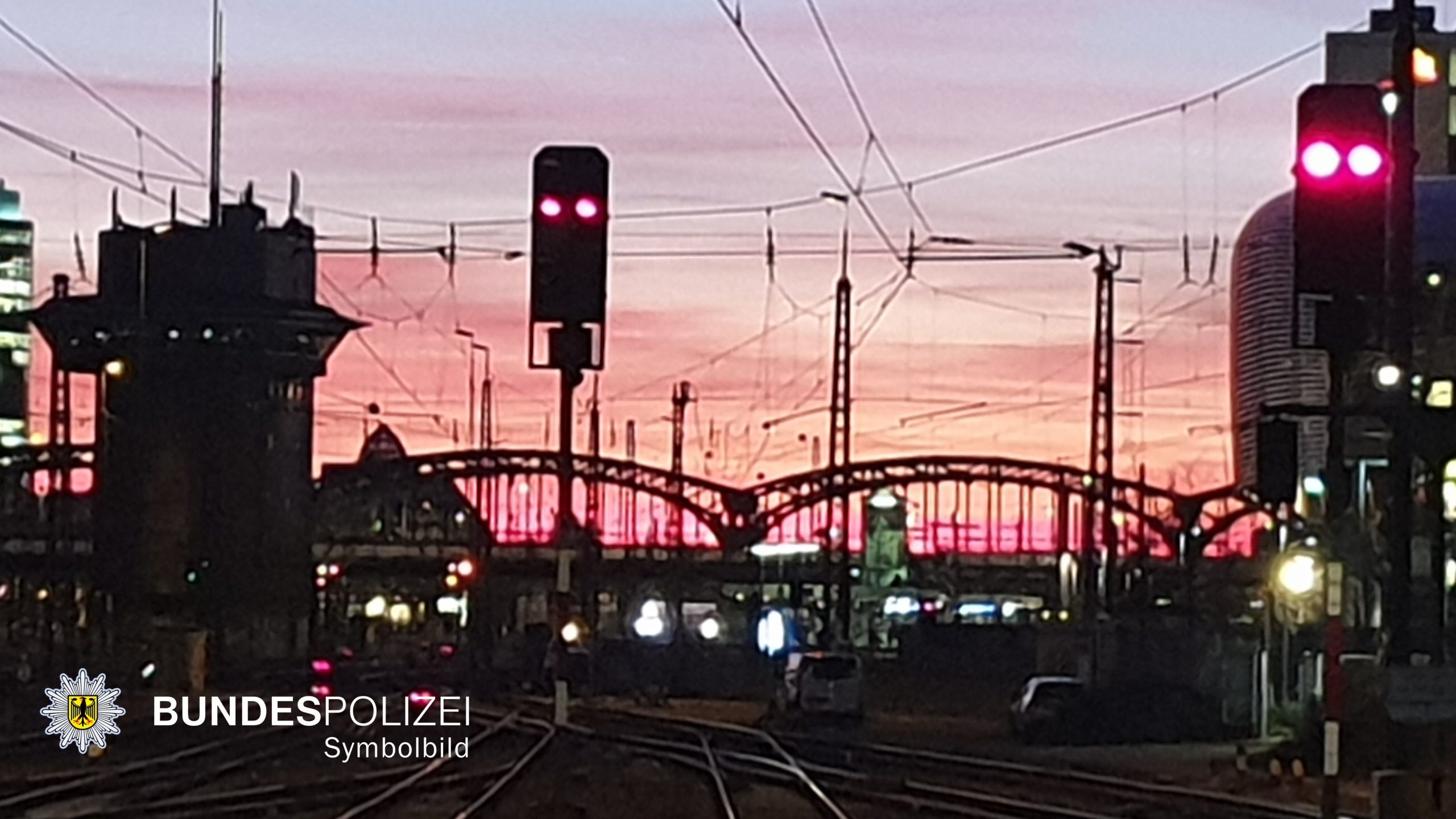 Blick auf Gleise am Hauptbahnhof München bei Abenddämmerung mit Rot-Signalen