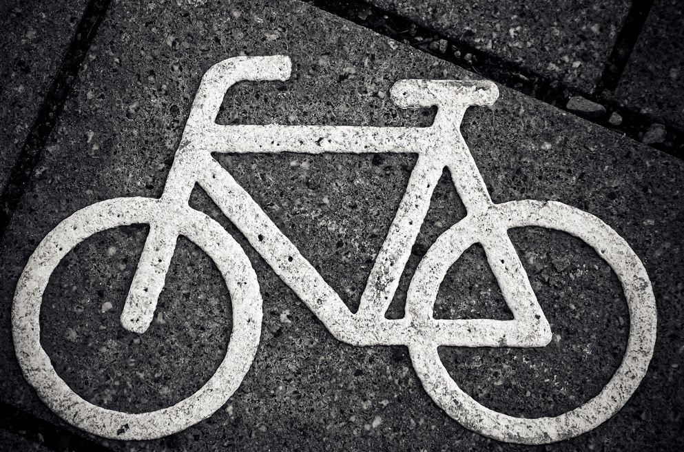 Fahrrad weiß auf schwarzem Straßenbelag aufgemalt