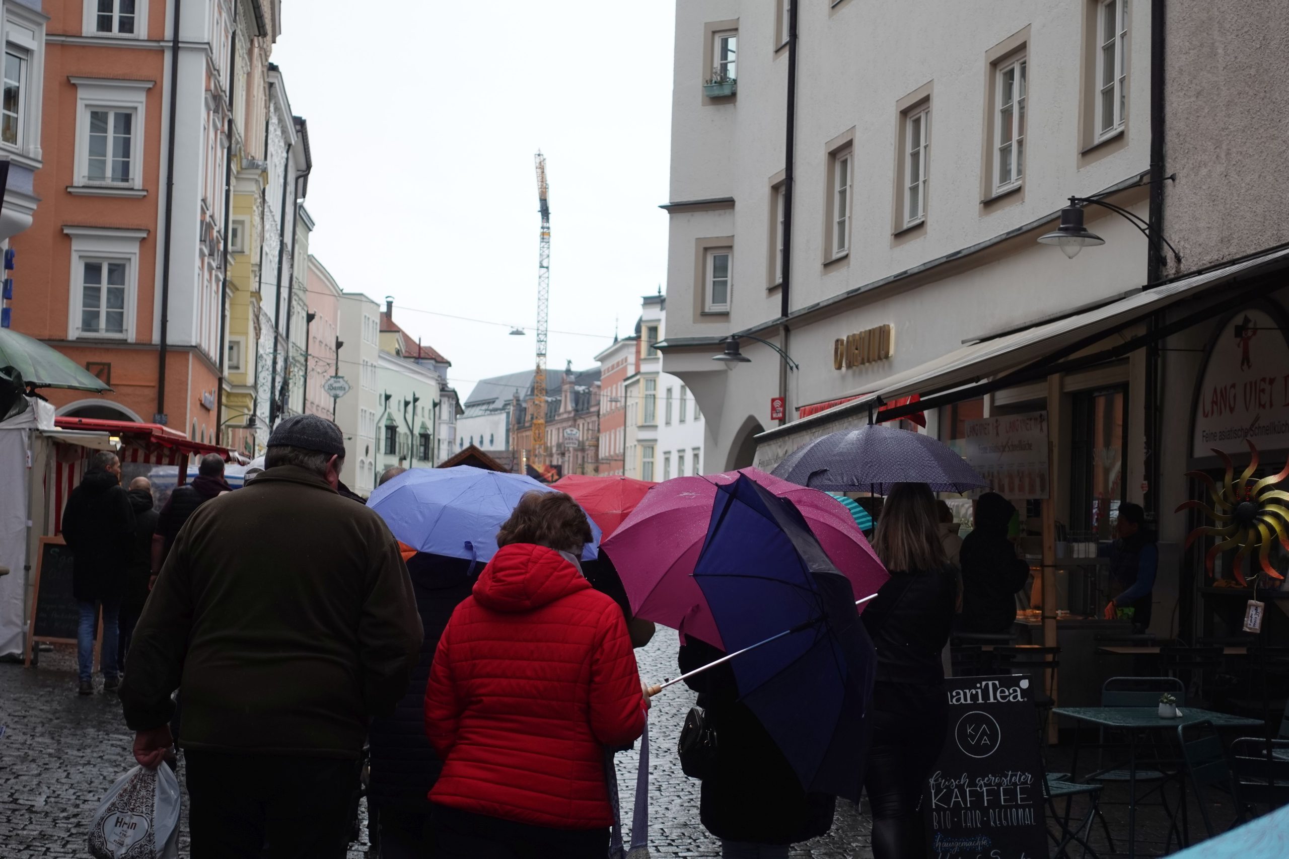 Besucher mit Regenschirmen von hinten fotografiert auf dem Max-Josefs-Platz