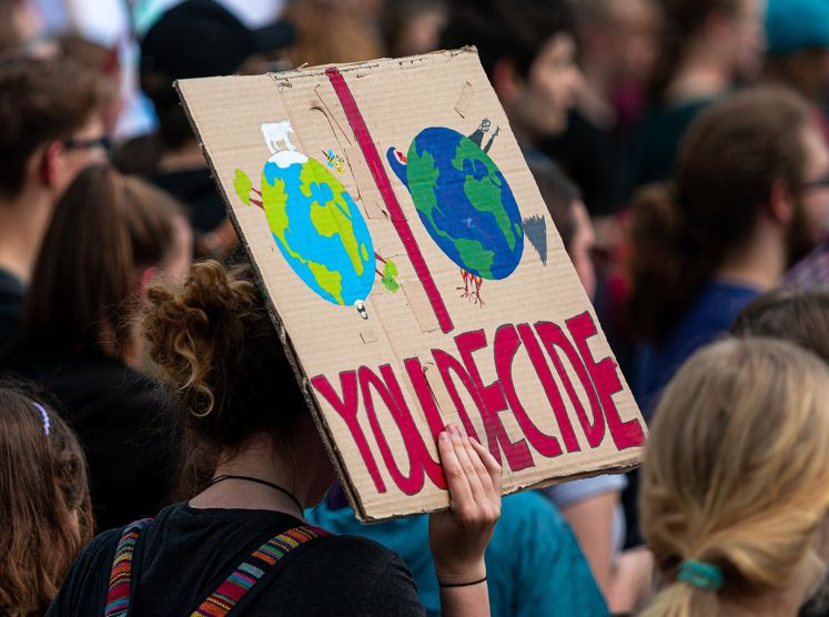 Klimastreik. Demonstranten halten Schild in die Höhe mit Erde schön und Erde, der die Luft ausgeht mit der Aufschrift: "You Decide"