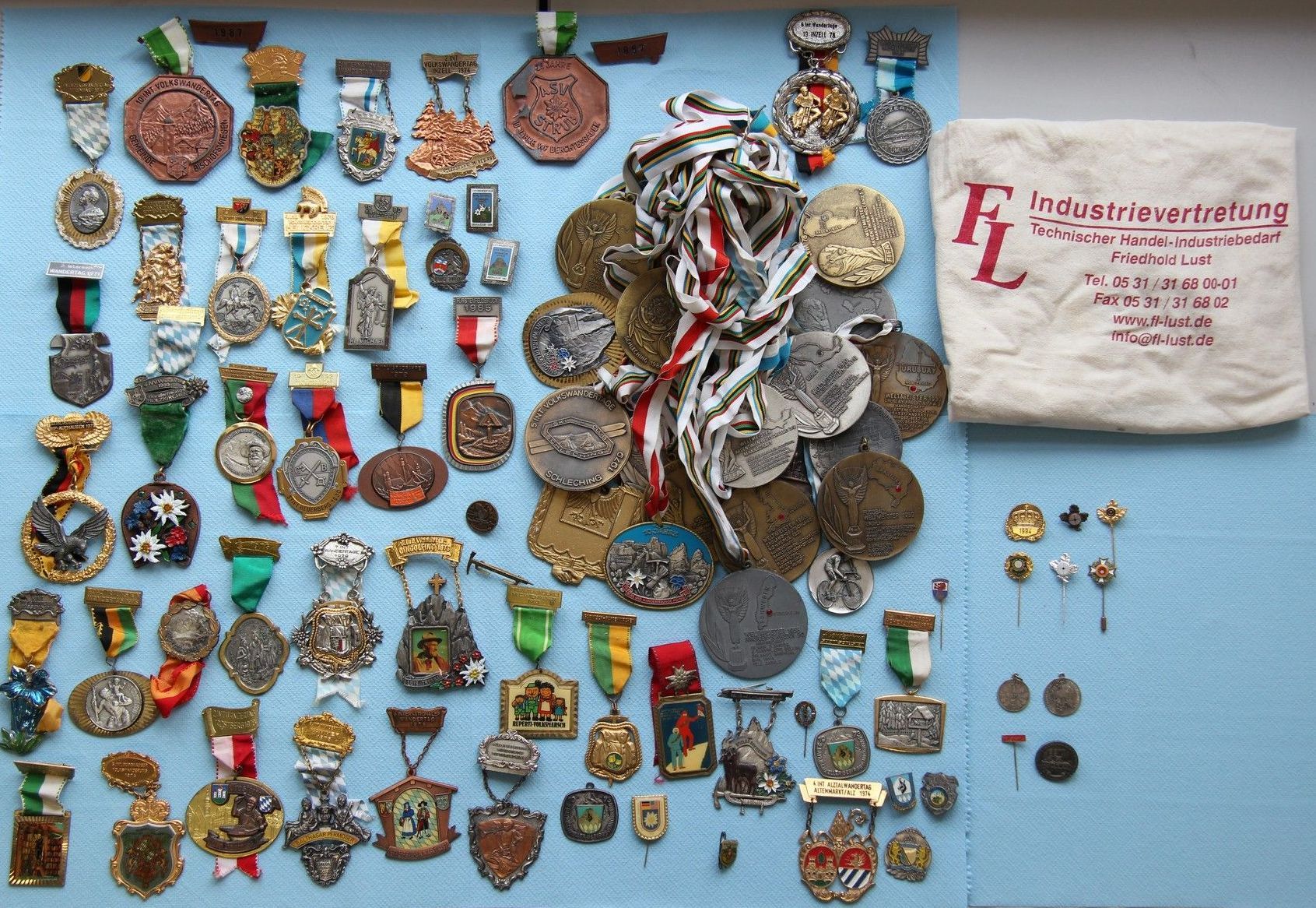 Zahlreiche Medaillen, Anstecknadeln und Abzeichen und eine Stoffbeutel: Foto: Polizeipräsidium Oberbayern Süd
