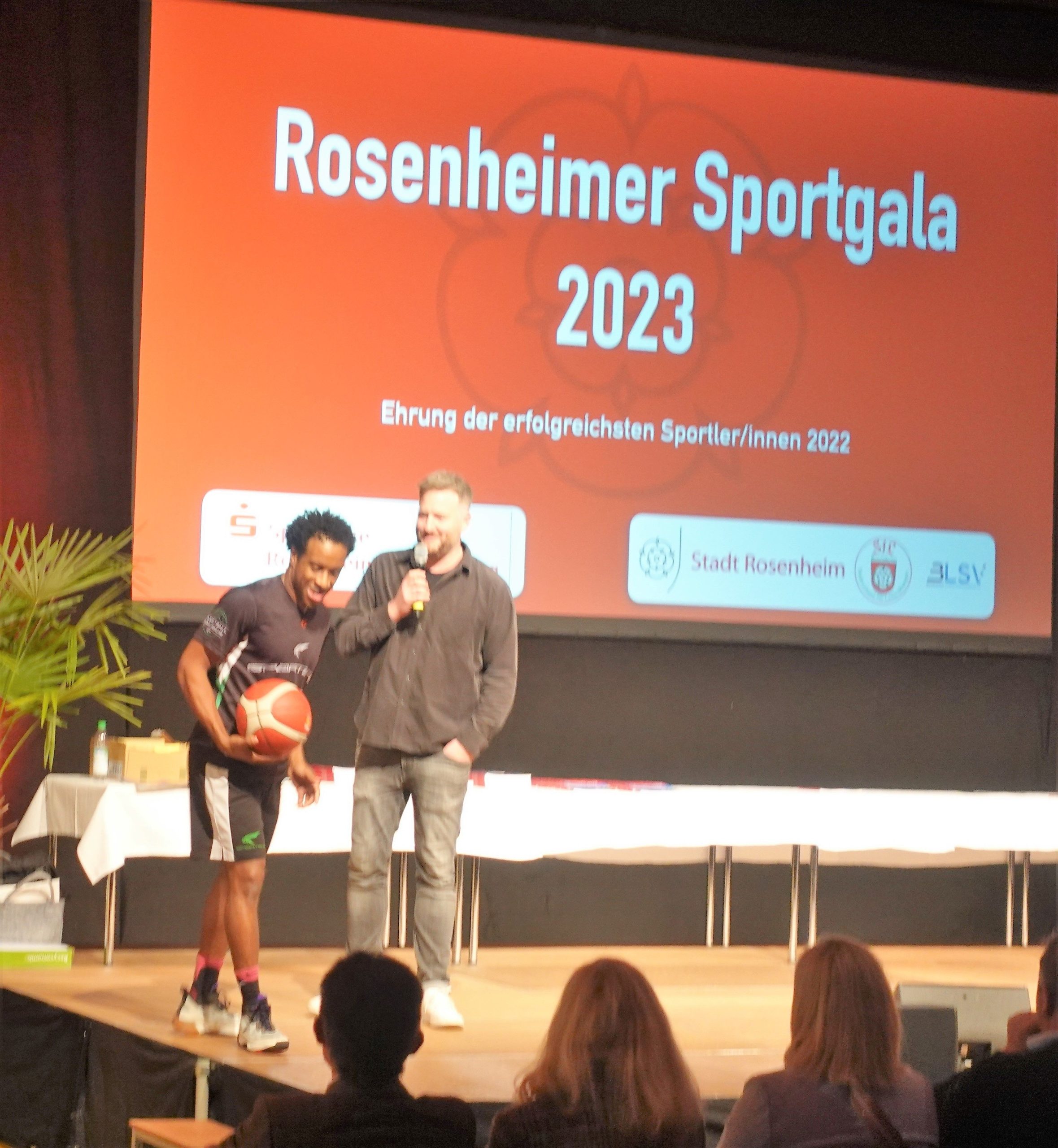Basketballer redet mit Moderator auf der Bühne der Sporgala Rosenheim