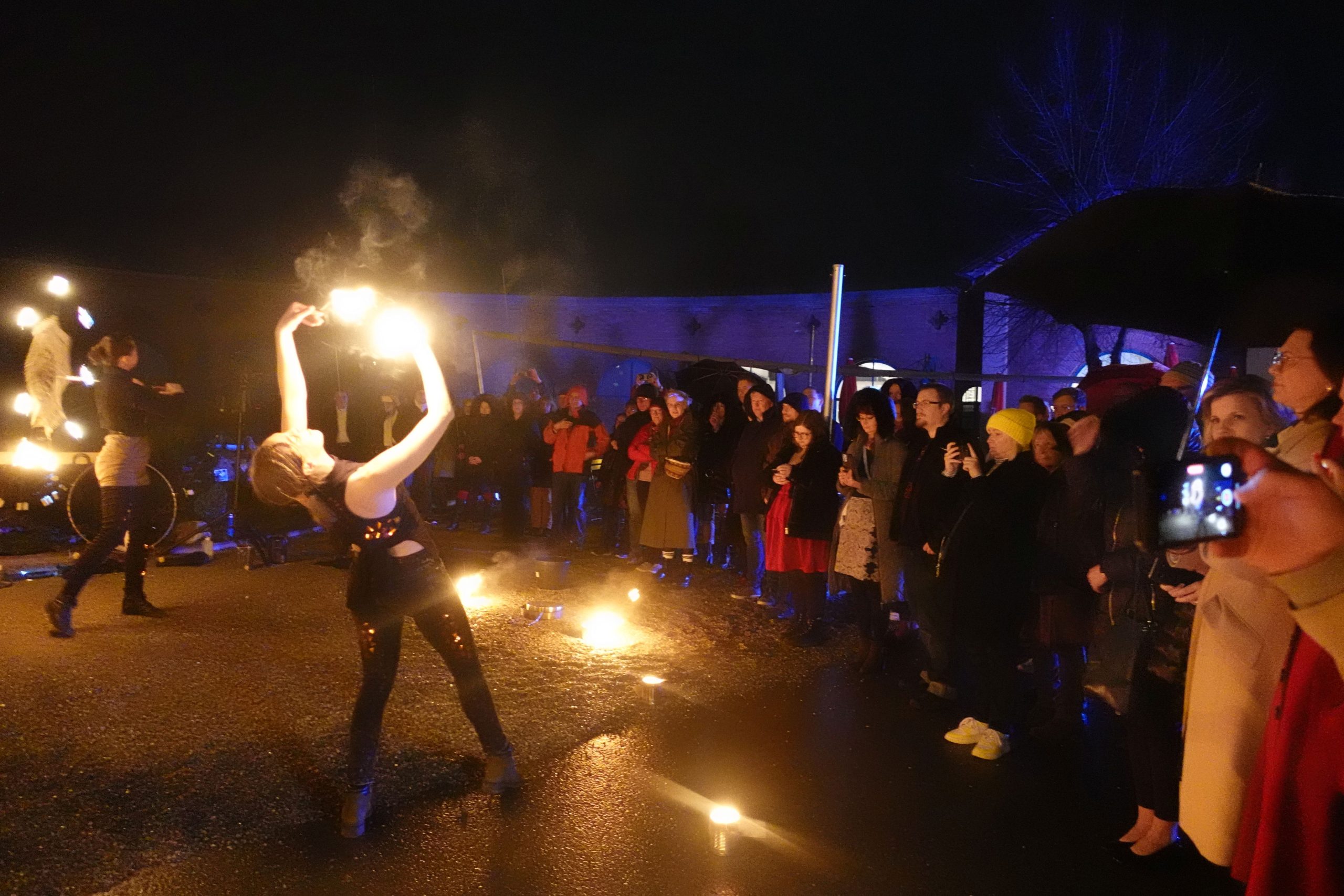 Feuerkünstlerin vor Publikum vor dem Ausstellungszentrum Lokschuppen in Rosenheim bei Nacht