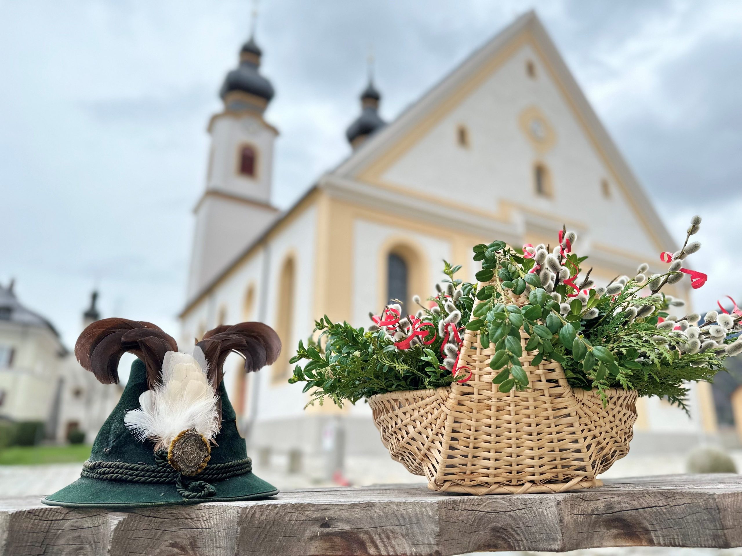 Trachtenhut und Palmbuschen in Korb vor Pfarrkirche in Aschau im Chiemgau