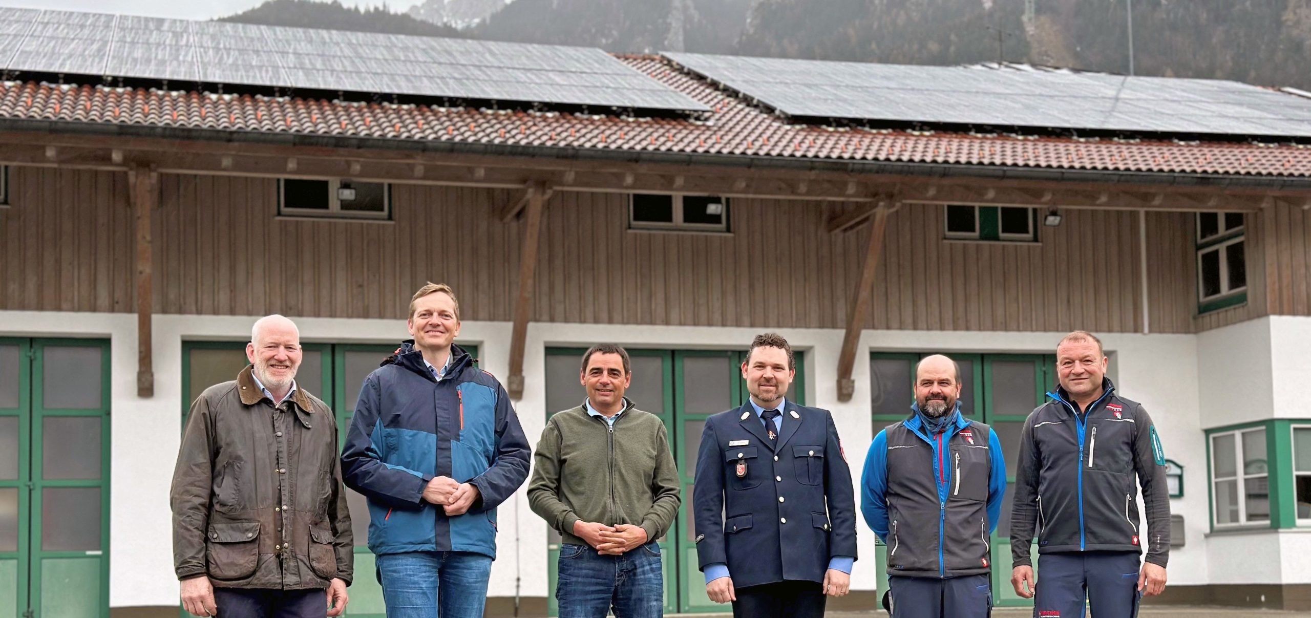 Foto mit sechs Männern vor dem Feuerwehrhaus Aschau im Chiemgau mit neuer PV-Anlage auf dem Dach. Foto: H.Reiter