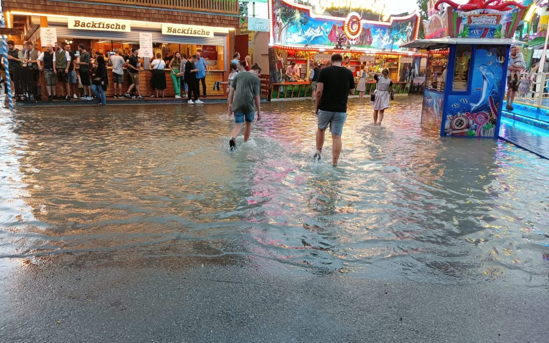 Wiesnbesucher waten durch Wassermassen