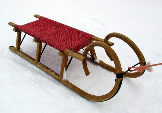 Schlitten mit roter Auflage im Schnee