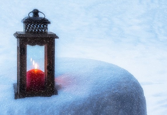 Laterne Laterne mit brennender Kerze im Schnee. Foto: re