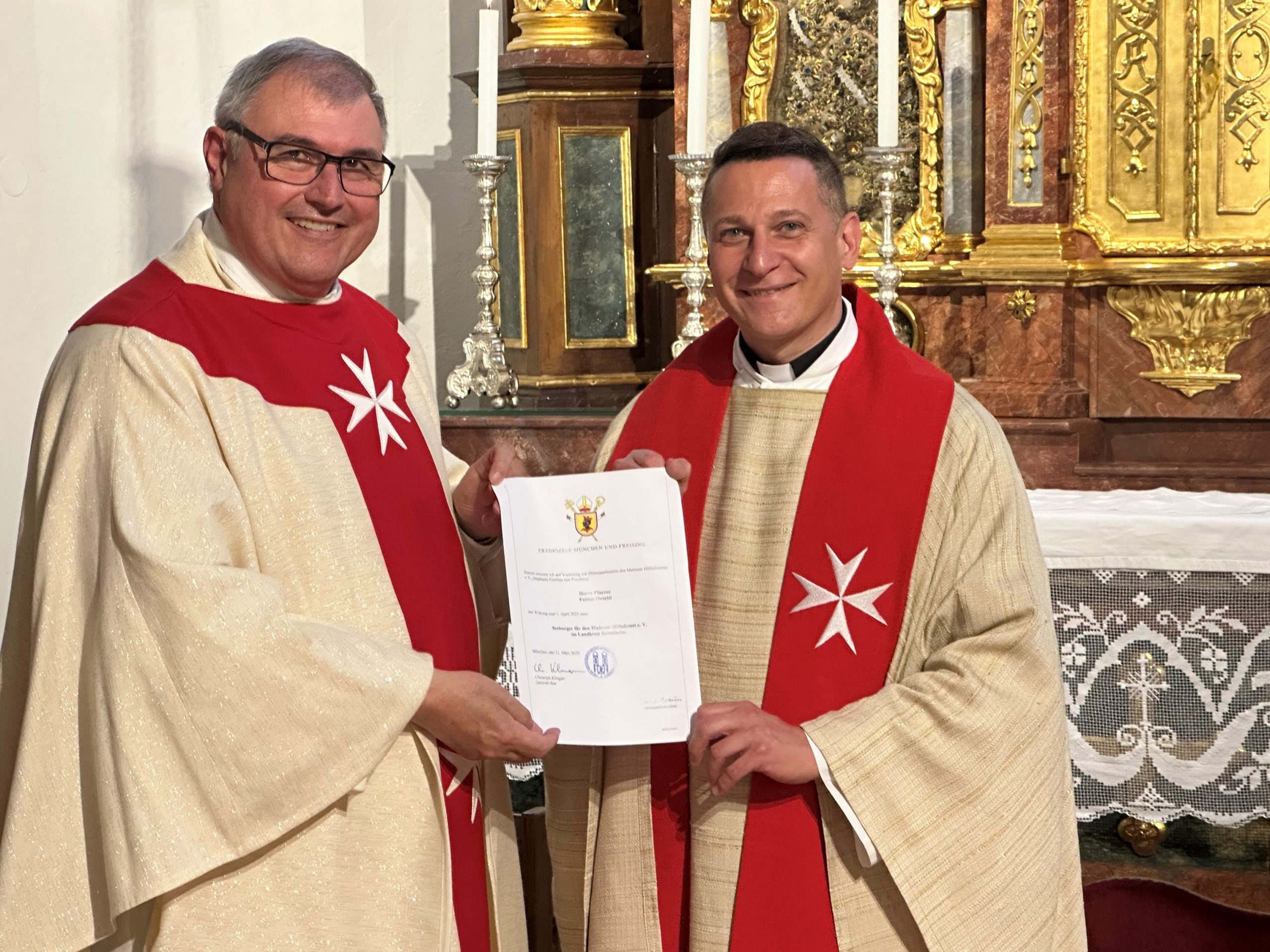 c)DanielReichel Domkapitular Hans-Georg Platschek (li.), Seelsorger der Malteser im Erzbistum München und Freising, überreichte Prodekan Fabian Orsetti, Leiter des Pfarrverbands Stephanskirchen, die Berufungsurkunde zum Seelsorger für die Malteser in Stadt und Landkreis Rosenheim. Foto: Copyright Daniel Reichel
