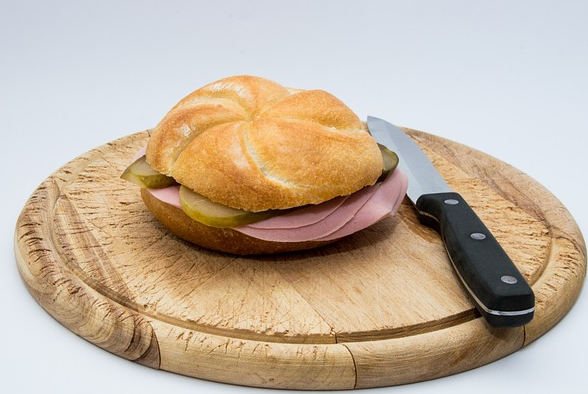 Wurstsemmel Wurstsemmel auf Holzbrett mit Messer. Foto: re