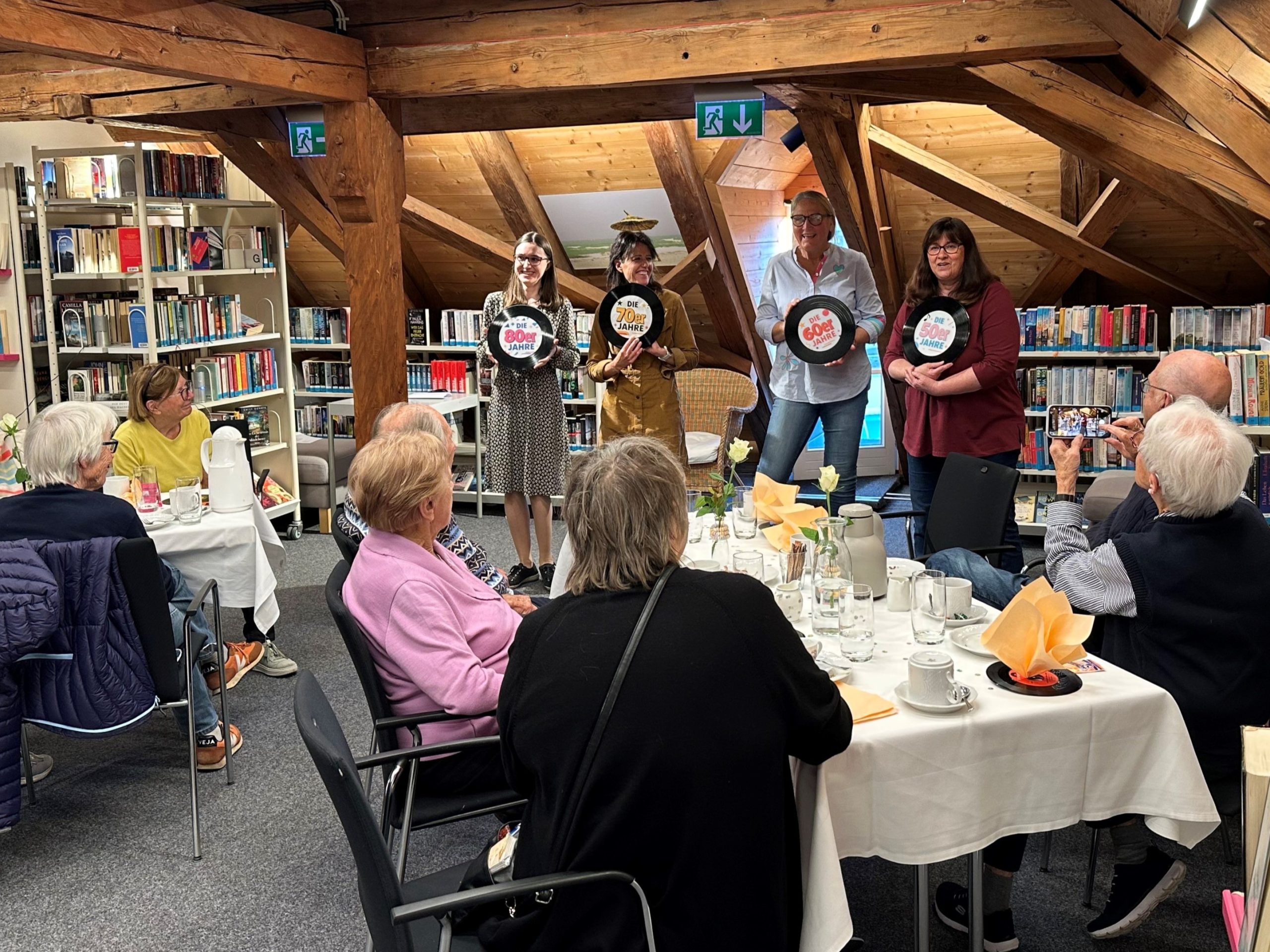2025-11-04-Pressebild 03 Bücherei Seniorencafé-neu Mit Humor und Nostalgie führte das Team der Bücherei Prien – (von links) Melanie Schieber, Bianca Radlinger, Moni Zech und Uschi Ziegler – durch das Seniorencafé. Besonders beim Musikspiel konnten die ältesten Leser ihr Wissen über Lieder aus den 50er- bis 80er-Jahren einbringen. Foto: Copyright Markt Prien am Chiemsee