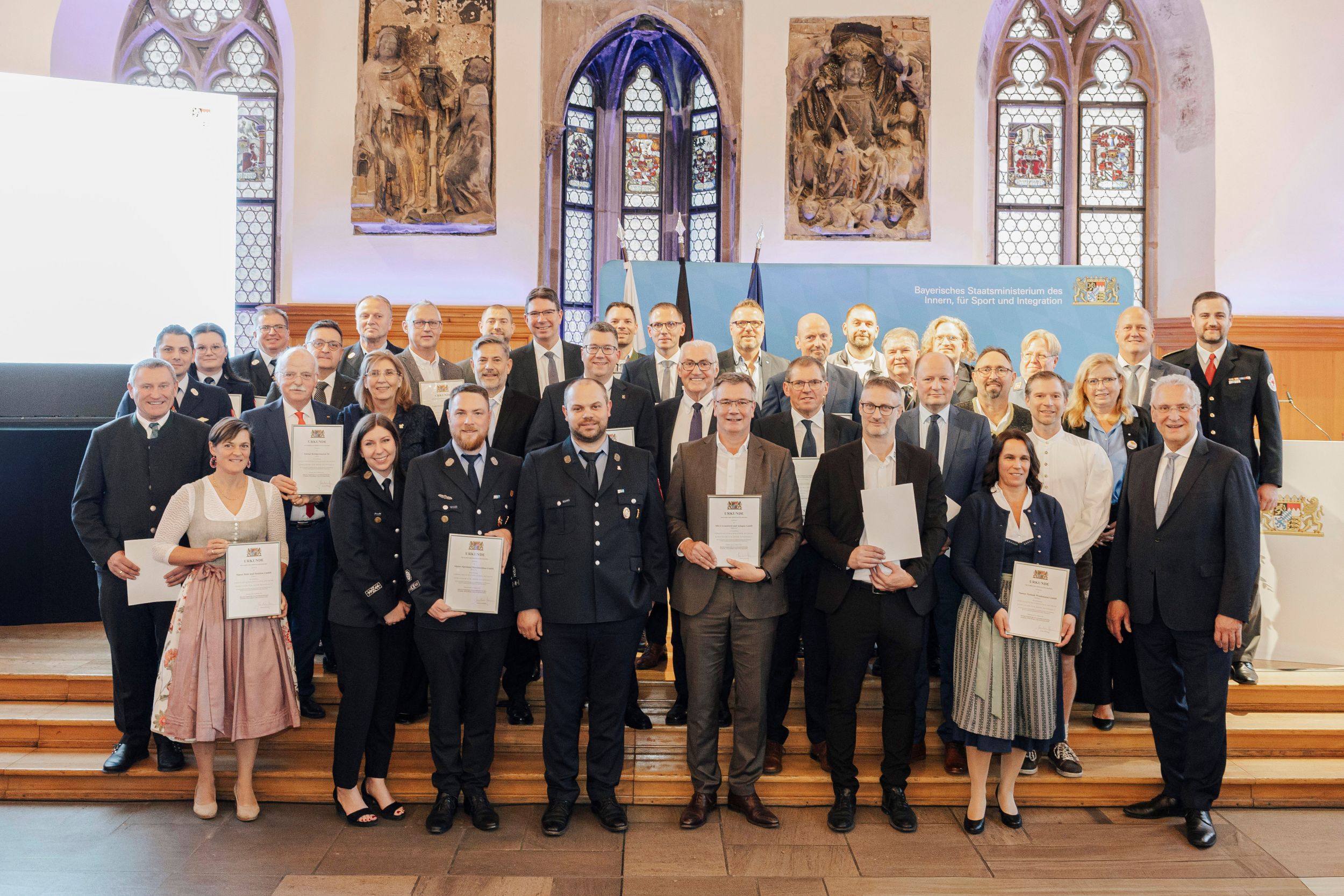 Alle Geehrten Die Adelholzener Alpenquellen wurden im historischen Rathaussaal in Nürnberg als „Ehrenamtsfreundlicher Betrieb – Gemeinsam für mehr Sicherheit“ ausgezeichnet. Stefan Thurner und Peter Lachenmeir durften die Ehrung aus den Händen des Bayerischen Innenministers Joachim Herrmann in Empfang nehmen (von links nach rechts) Foto: Copyright BayStMI