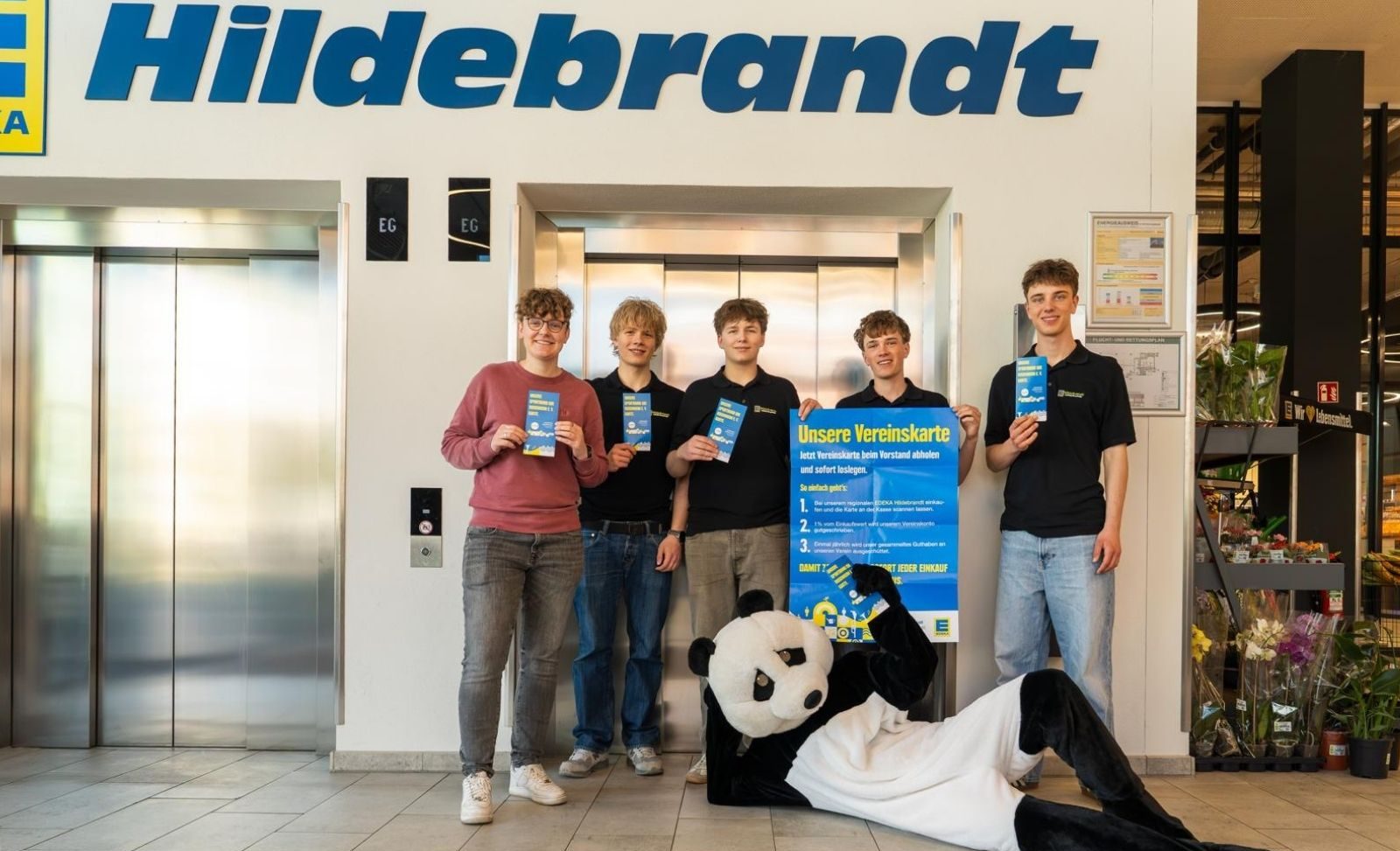 Edeka x Sportbund Symbolischer Start der Kooperation: Bei der Übergabe der Sportbund-Karten freuen sich das Maskottchen von EDEKA, Mitarbeiter von EDEKA Hildebrandt sowie die Leitung der Geschäftsstelle des Sportbund DJK Rosenheim e.V. über die neue Partnerschaft. Copyright DJK Rosenheim e.V.