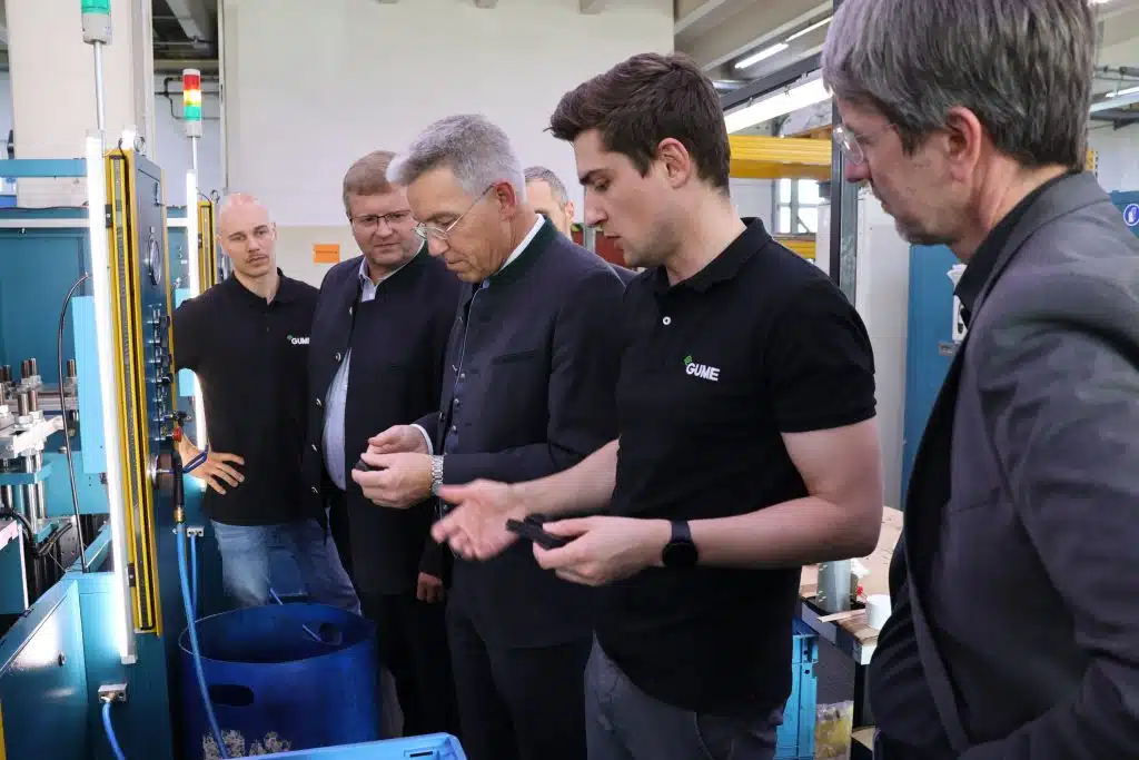 GUME-in-Produktion-1024×683 Michael Obermeyer gibt Bürgermeister Christian Mayer, Landrat Otto Lederer (beide links im Bild) und Andreas Bensegger (rechts im Bild) einen Einblick in die Produktion von Gummi-Formteilen. Foto: Landratsamt Rosenheim